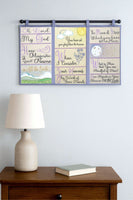 Decorative wall hanging with inspirational text on a light gray wall above a wooden cabinet with a lamp and book.